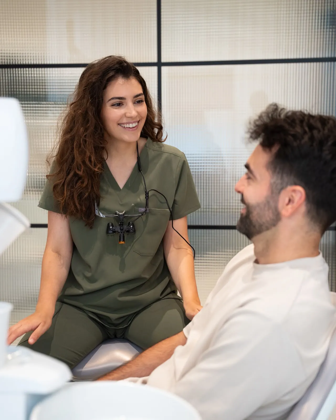 A dentist talking with a patient in a DC360 treatment room