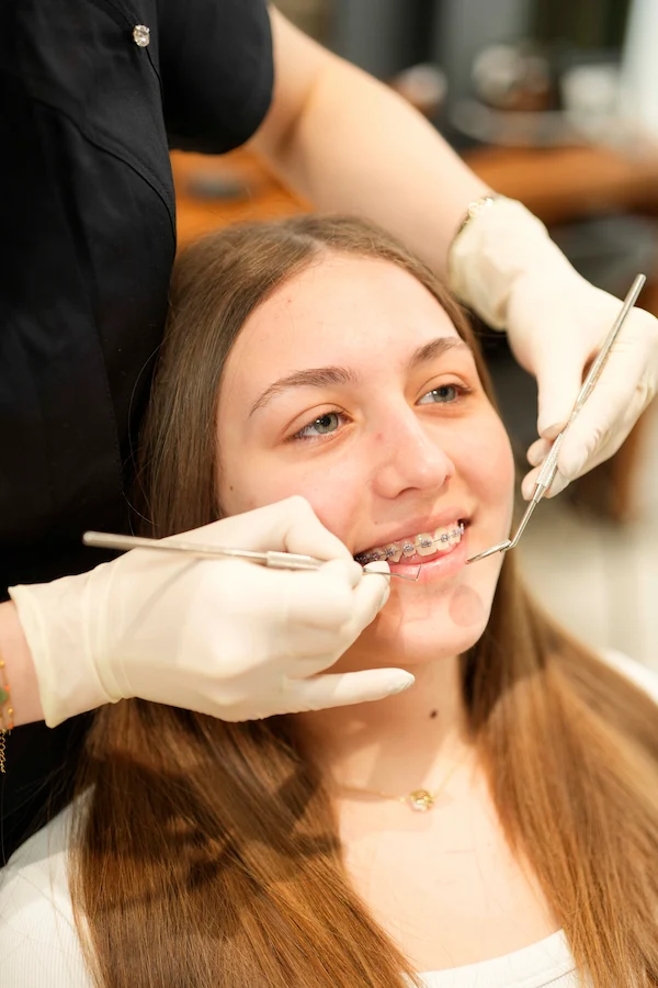 An orthodontic check-up of a girl with fixed braces