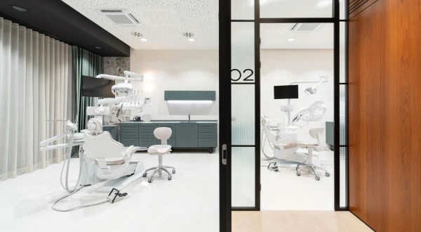 A DC360 treatment room with two dental chairs and a glass partition